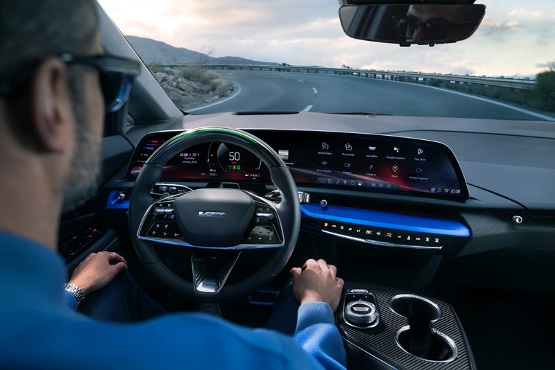 Front View of the 2026 OPTIQ-V Driving Through the Dusk Utilizing its Headlights | Courtesy Cadillac Broussard in Broussard LA